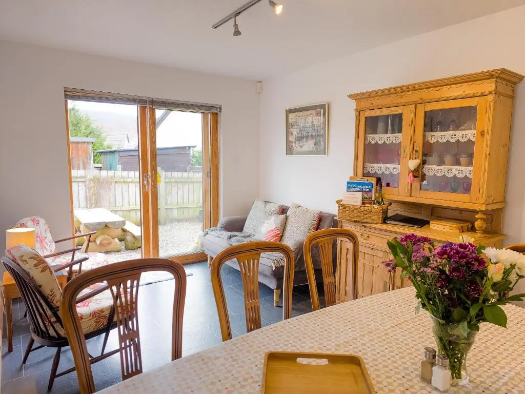 a living room with a table and chairs and a couch at Dalfern Lodge in Aviemore