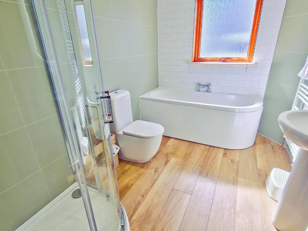 a bathroom with a tub and a toilet and a sink at Dalfern Lodge in Aviemore