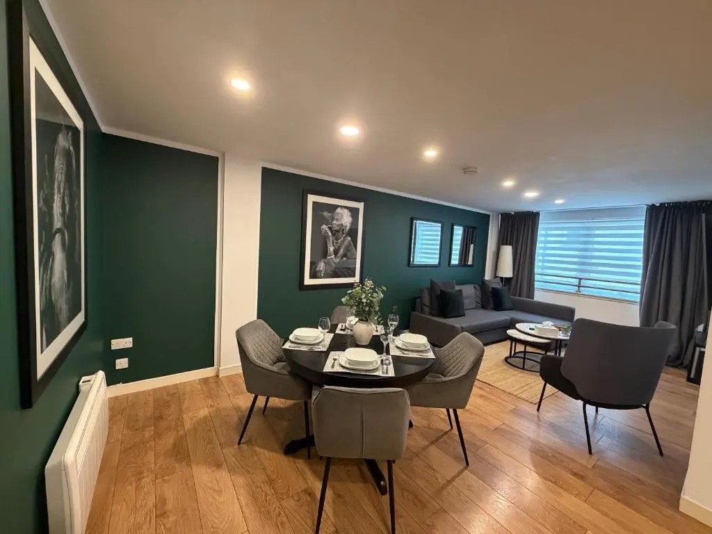 a living room with a table and chairs and a couch at GRAPHITE APARTMENTS in Inverness