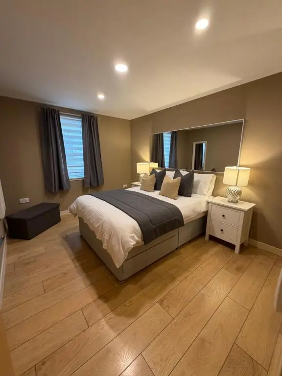 a bedroom with a large bed with a large mirror at GRAPHITE APARTMENTS in Inverness
