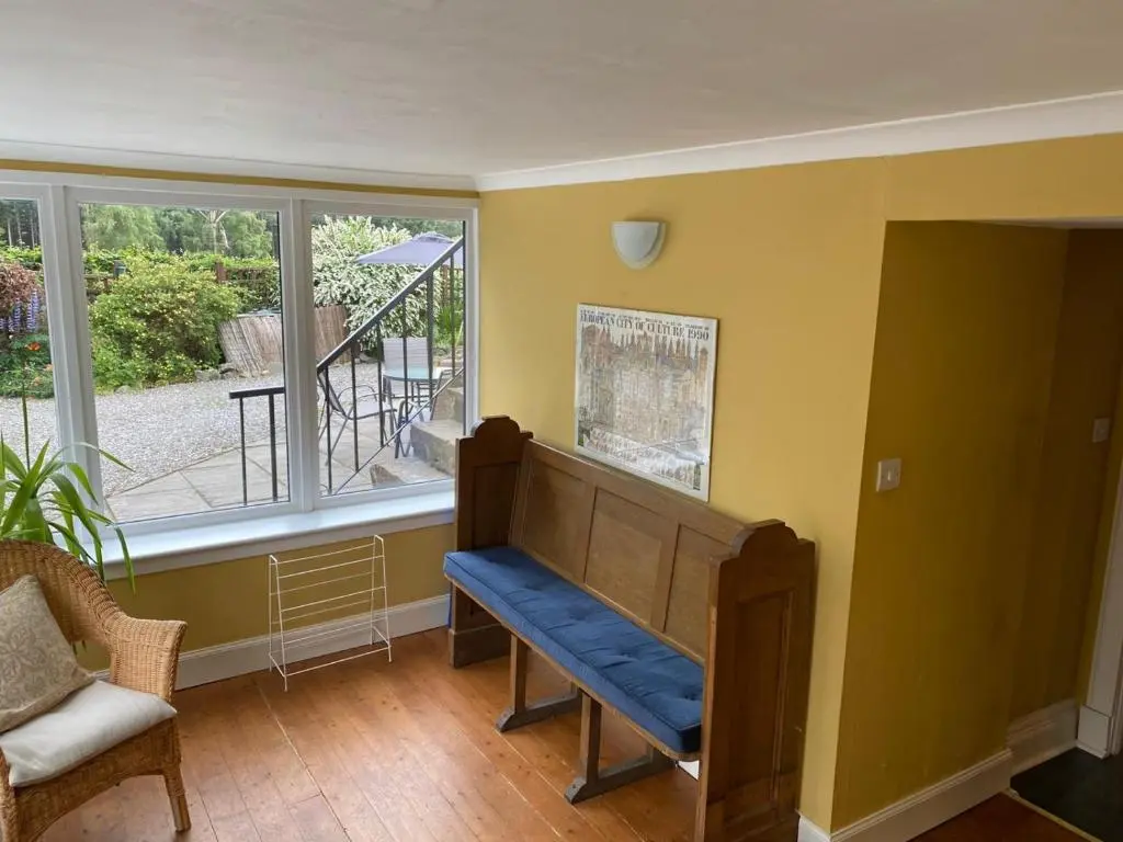 a room with a bench in front of a window at Granite Cottage in Nethy Bridge