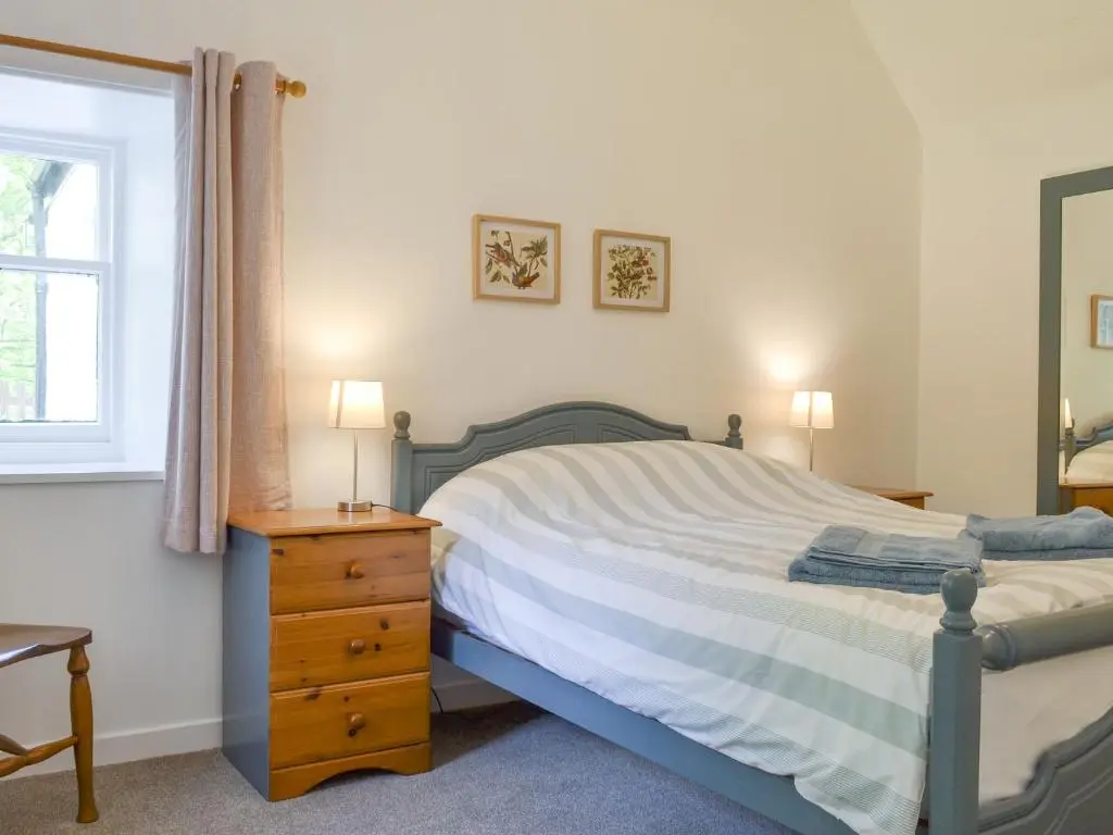 a bedroom with a bed and a dresser and a window at Eagles Gate Lodge in Banff