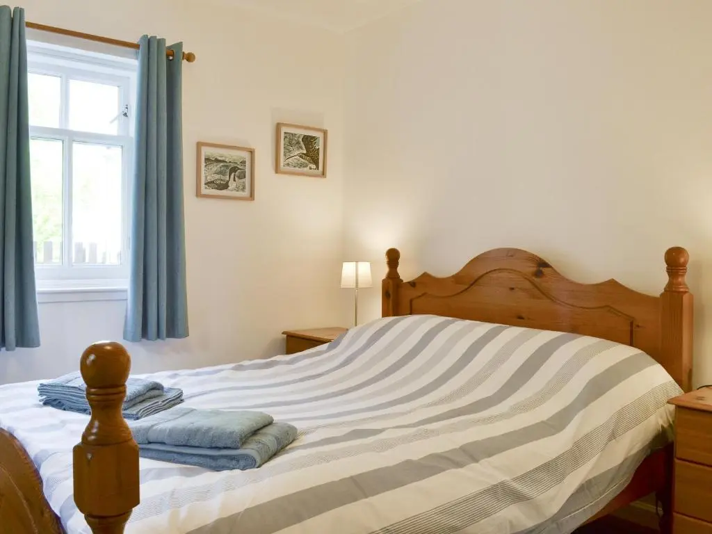 a bedroom with a wooden bed with a window at Eagles Gate Lodge in Banff