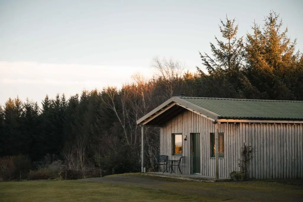 a small shed with a table and chairs in a yard at The Bothy at Coneloch in Elgin