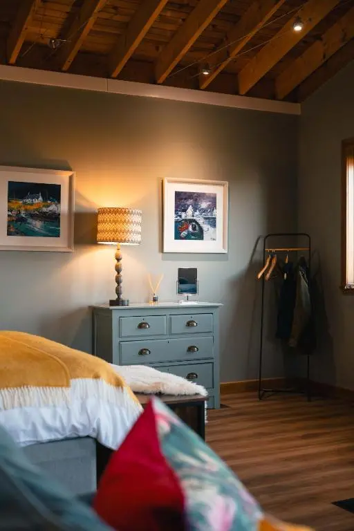 a bedroom with a bed and a dresser at The Bothy at Coneloch in Elgin