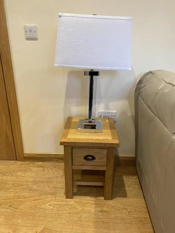 a lamp on a table next to a bed at Waverley Inn Holiday Apartments in Inverness