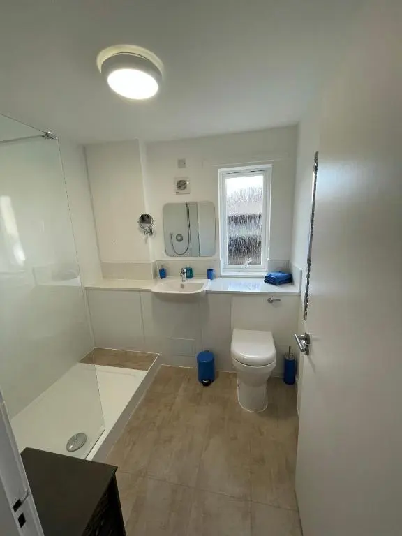 a bathroom with a toilet and a sink and a window at Lesmurdie Court, Serviced Accommodation Moray in Elgin