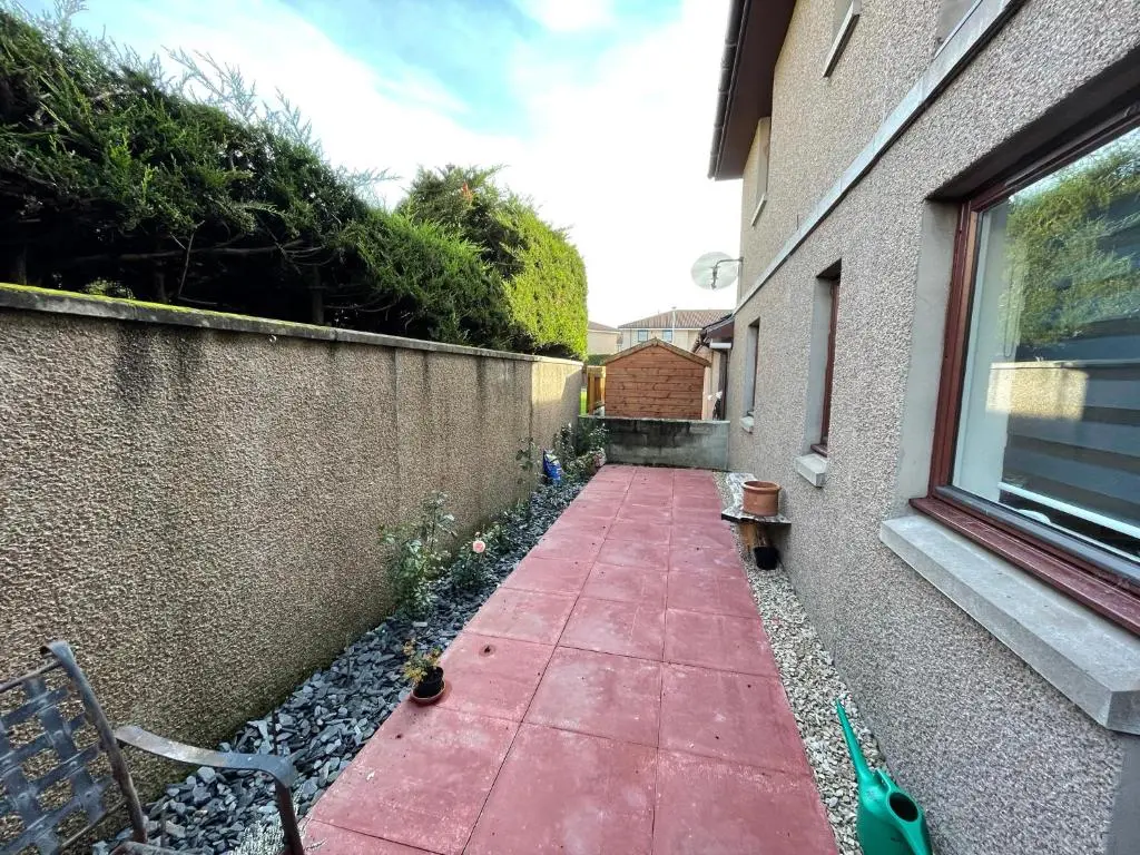 a sidewalk next to a building with a window at Lesmurdie Court, Serviced Accommodation Moray in Elgin