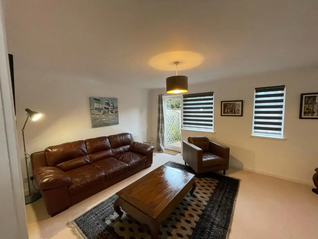 a living room with a leather couch and a coffee table at Lesmurdie Court, Serviced Accommodation Moray in Elgin