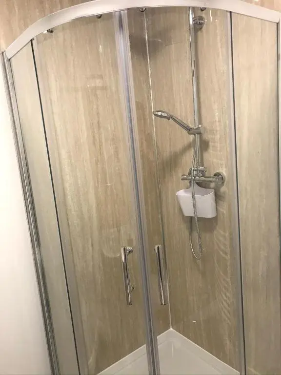 a shower with a glass door in a bathroom at Thistle House in Inverness
