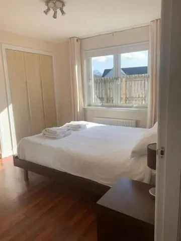 a bedroom with a large bed and a window at Tieveragh in Aviemore