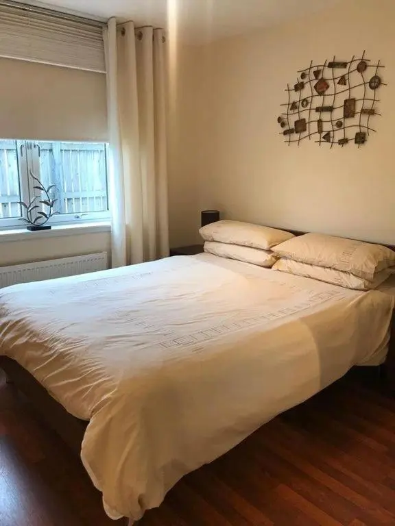 a bedroom with a large white bed with a window at Tieveragh in Aviemore