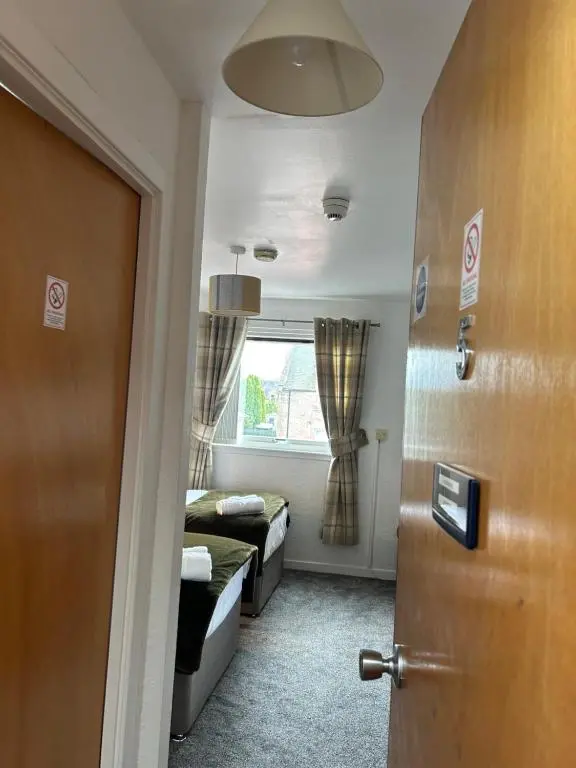 a room with a door and a bed and a window at Tay Villa in Inverness