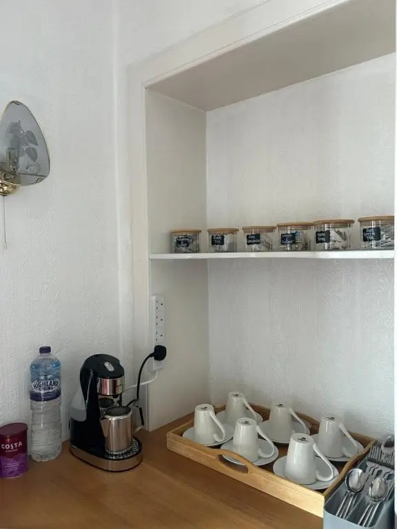 a kitchen with a counter with cups and a coffee maker at Tay Villa in Inverness