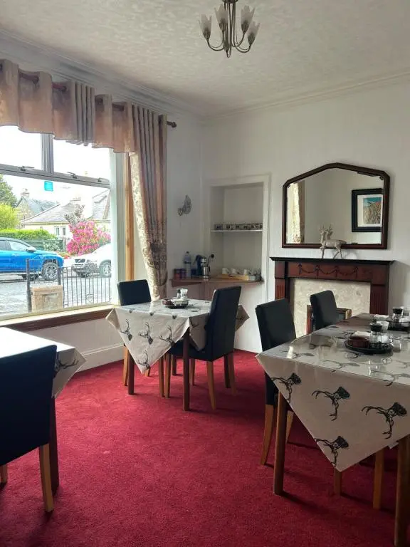 a dining room with a table and chairs and a mirror at Tay Villa in Inverness