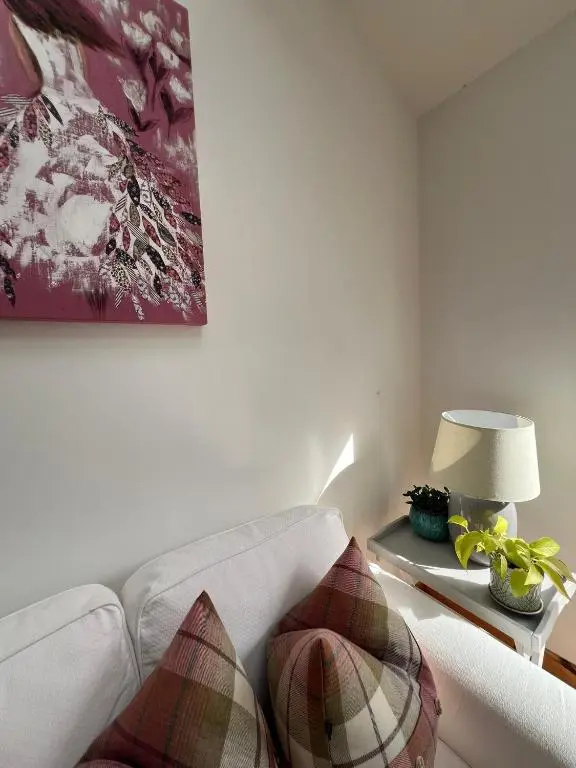 a living room with a white couch and a lamp at Balnakyle in Inverness