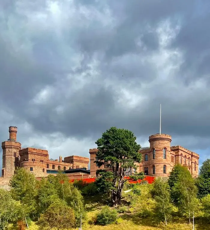 a large brick building with trees in front of it at Balnakyle in Inverness
