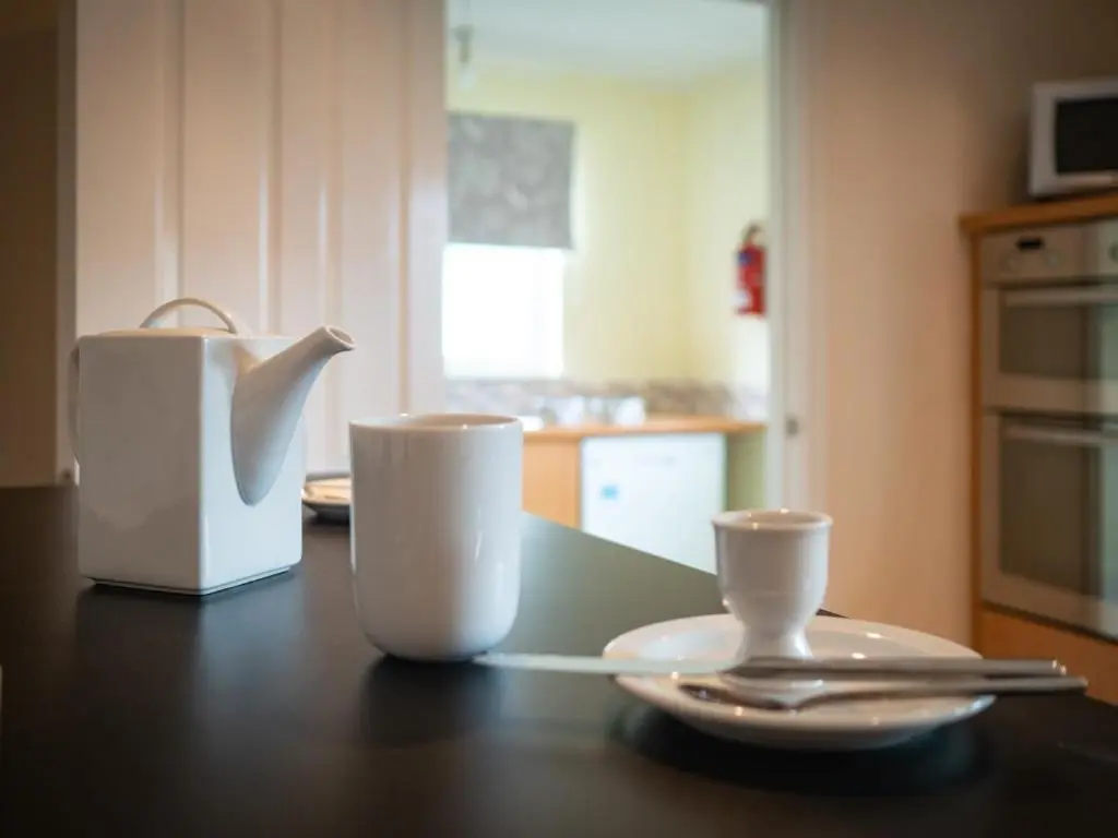 a table with two cups and a tea kettle at Eagle Lodge - Aviemore Lodges in Aviemore