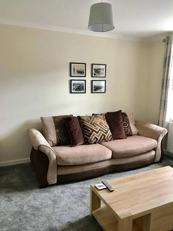 a living room with a couch and a coffee table at 2 Bedroom Townhouse on NC500, Wick, Highland in Wick