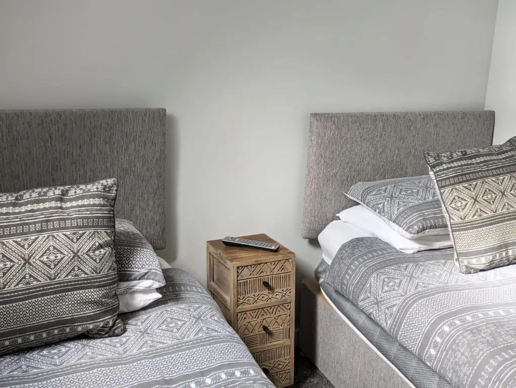 a bedroom with two twin beds and a night stand at 2 Bedroom Townhouse on NC500, Wick, Highland in Wick