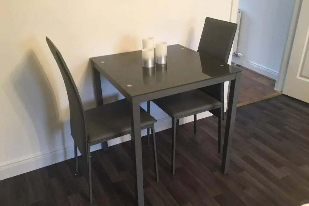 a black table with two chairs and two candles on it at The Annex at Bonnieview in Inverness