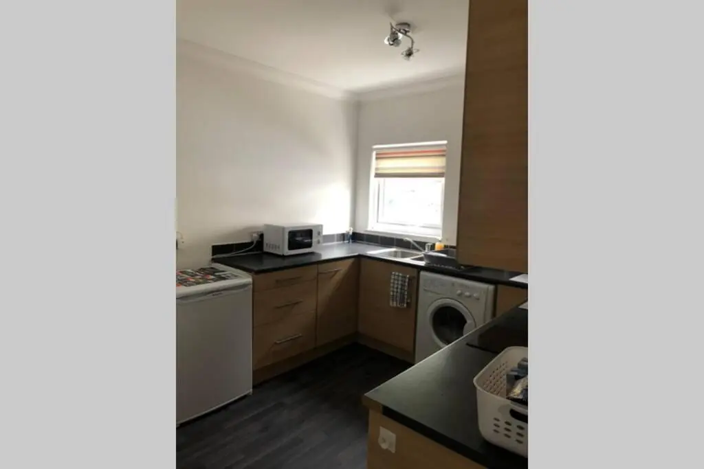 a kitchen with a washer and a sink and a window at The Annex at Bonnieview in Inverness
