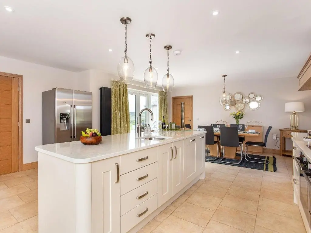 a kitchen with white cabinets and a kitchen island at Morven View in Dunbeath