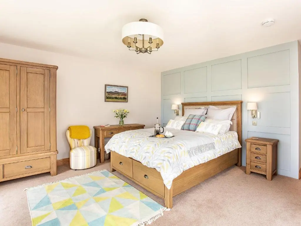 a bedroom with a bed and a chandelier at Morven View in Dunbeath