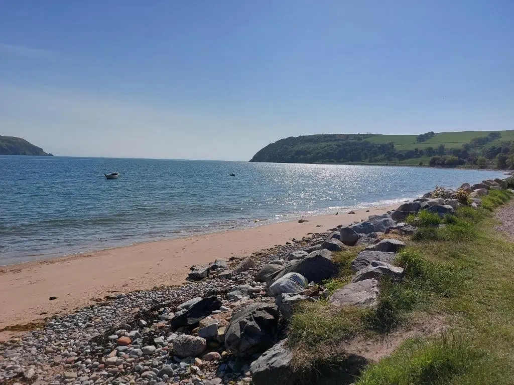 a beach with a bunch of rocks and the water at Paye House - Cromarty in Cromarty