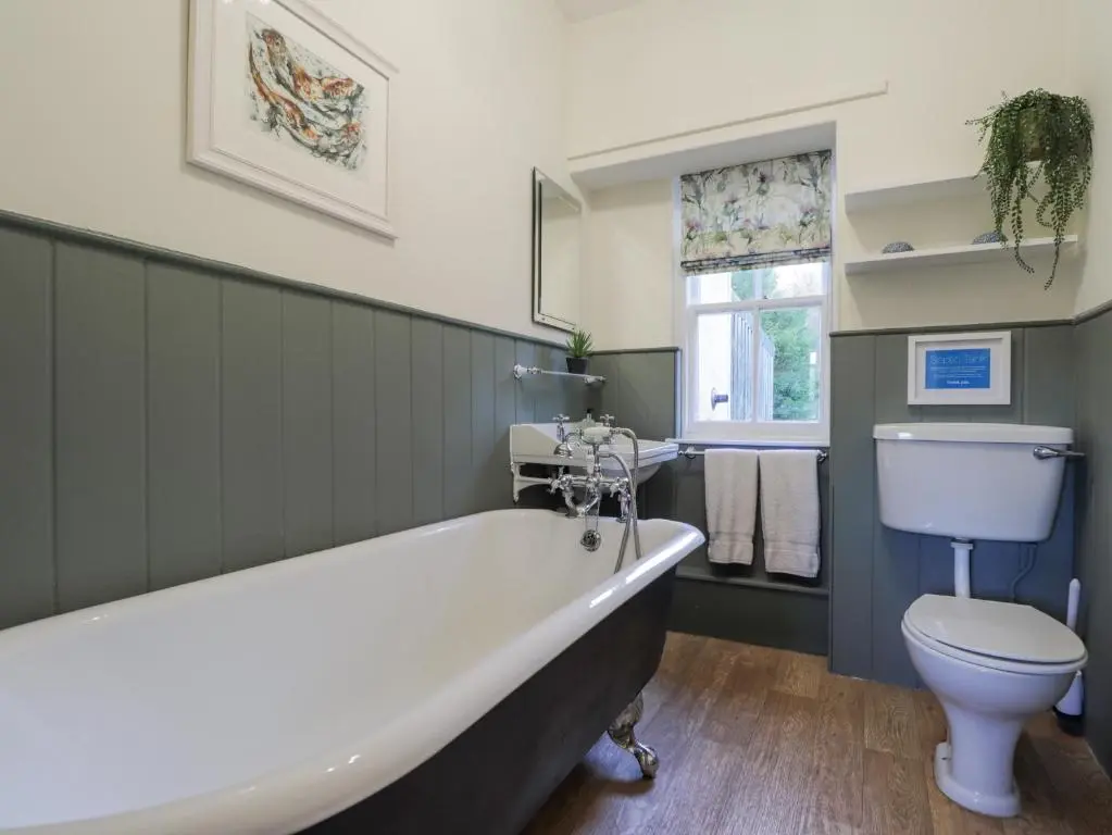 a bathroom with a bath tub and a toilet at Cormack Lodge - Brodie Castle in Forres