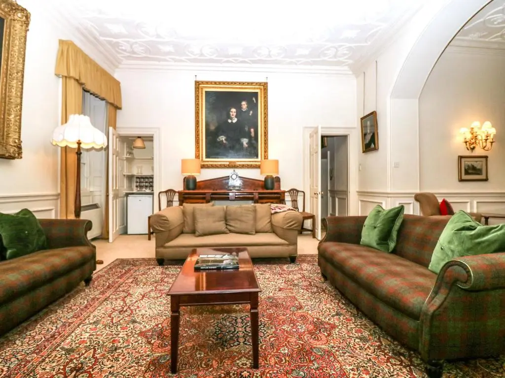 a living room with two couches and a table at The Preston Tower Apartment - Fyvie Castle in Turriff