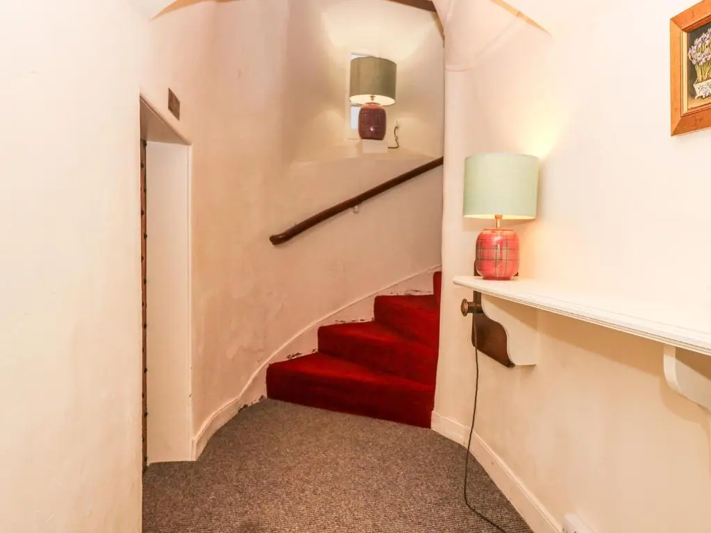 a stairway with a red carpet and a red staircase at The Preston Tower Apartment - Fyvie Castle in Turriff