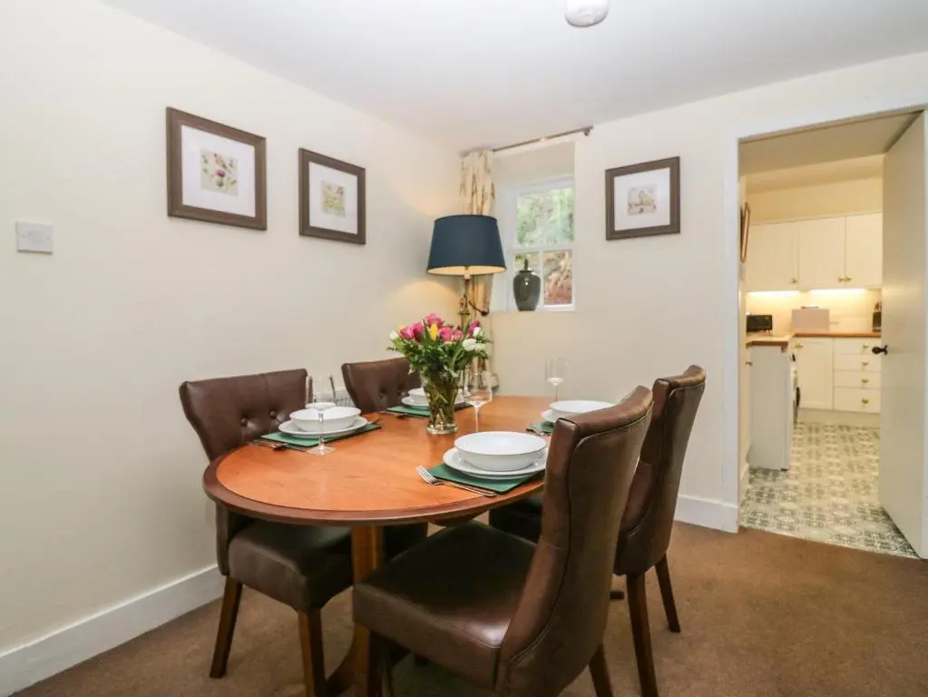 a dining room with a wooden table and chairs at North Mains Cottage - Craigievar Castle in Alford
