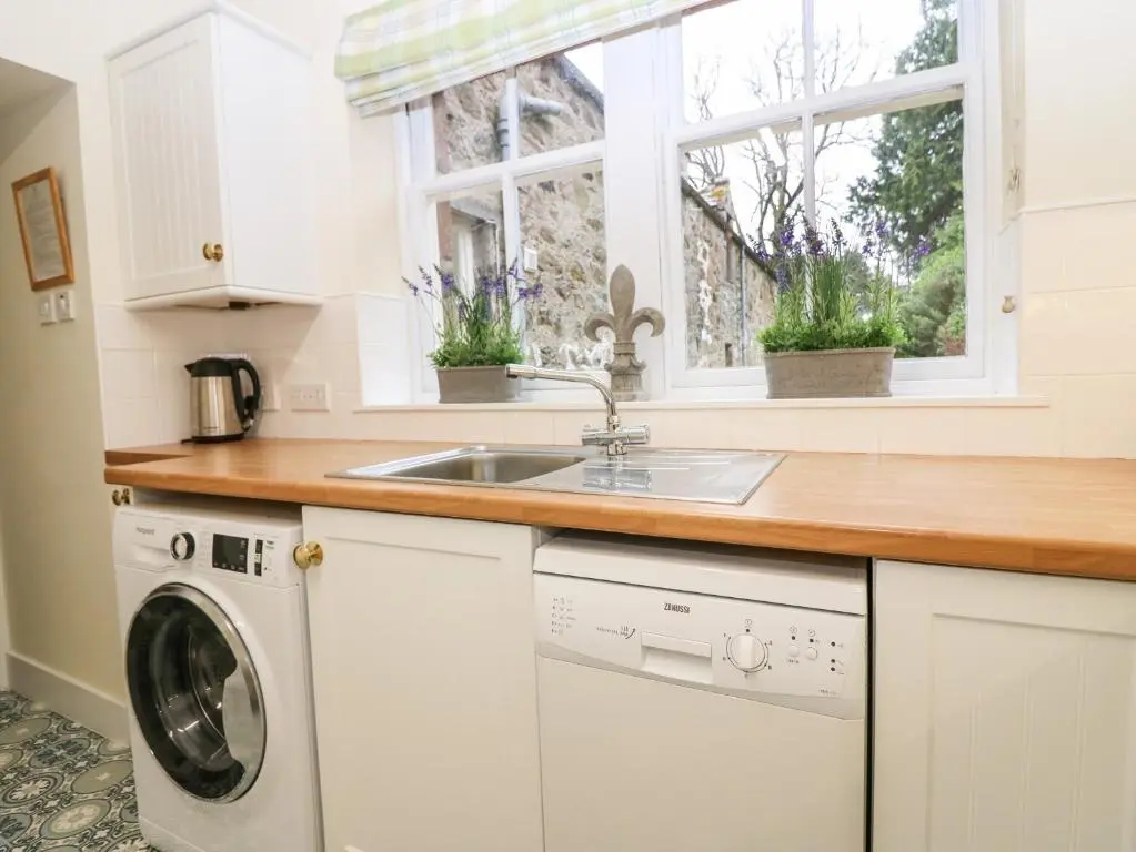 a kitchen with a sink and a washing machine at North Mains Cottage - Craigievar Castle in Alford
