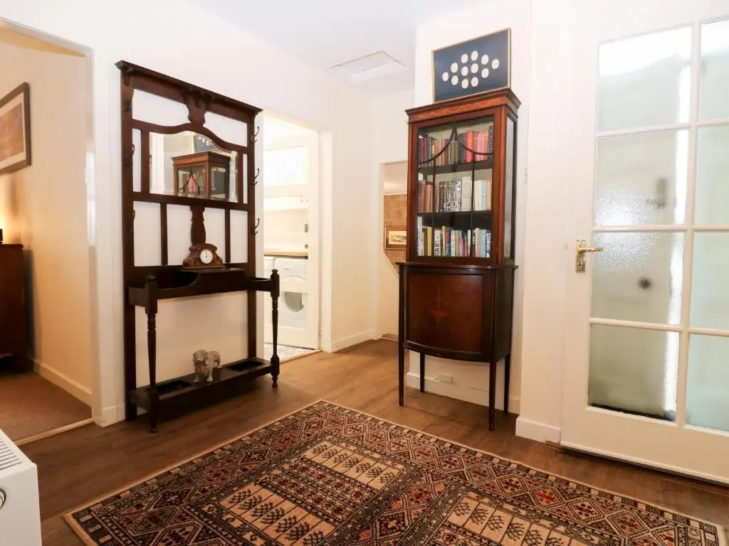 a living room with a book shelf and a rug at Steading Cottage - Craigievar Castle in Alford