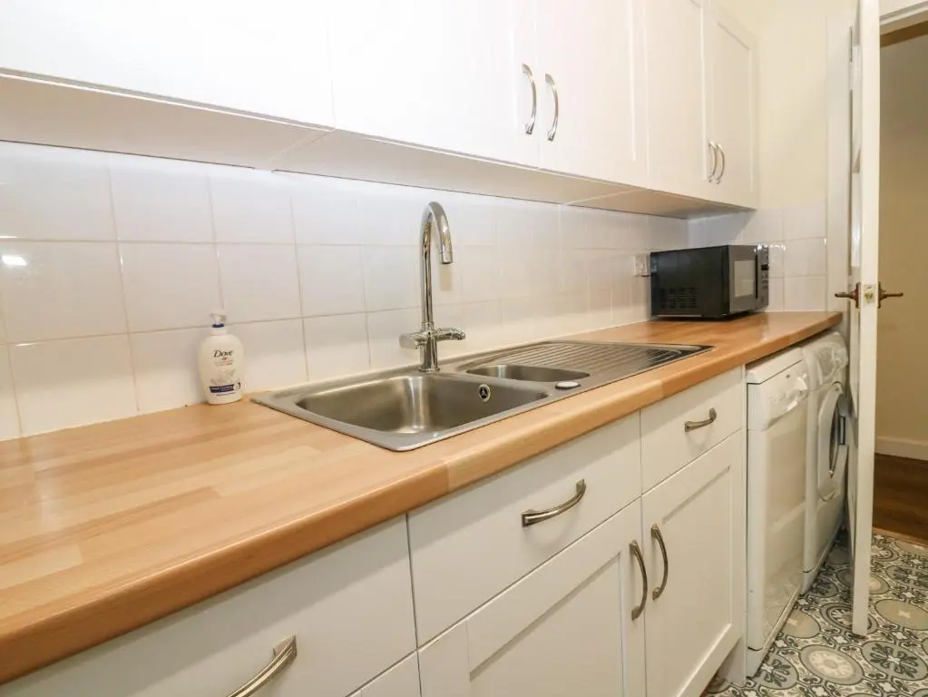 a kitchen with a sink and a microwave at Steading Cottage - Craigievar Castle in Alford