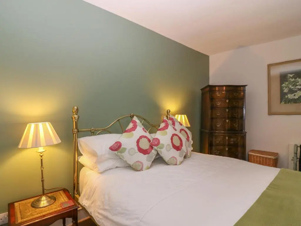 a bedroom with a bed with pillows on it at Courtyard Cottage - Drum Castle in Banchory