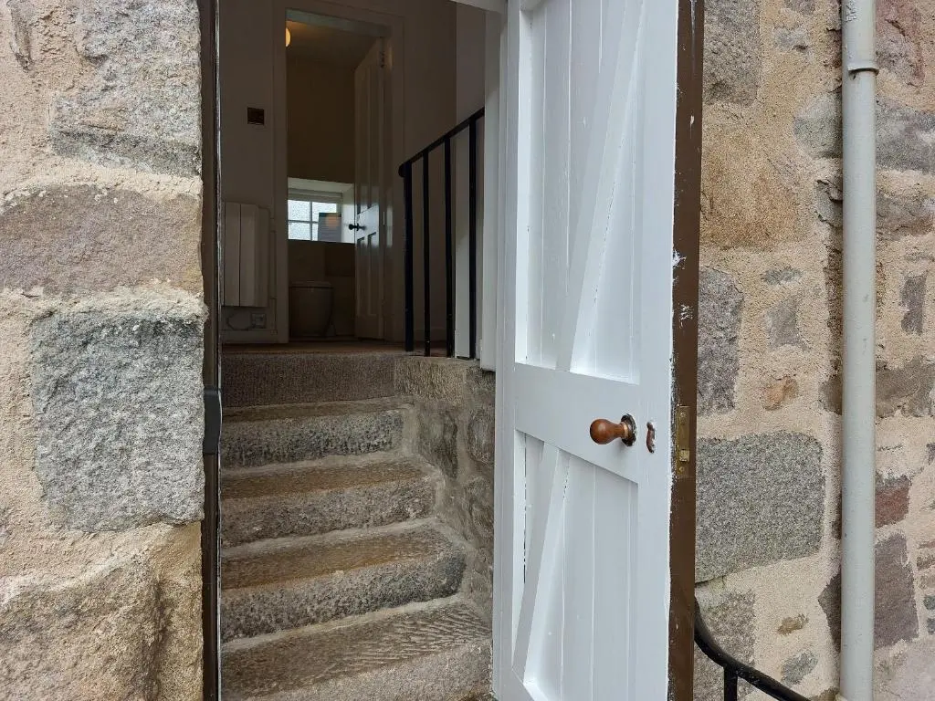 a door leading to a staircase in a stone house at Courtyard Cottage - Drum Castle in Banchory