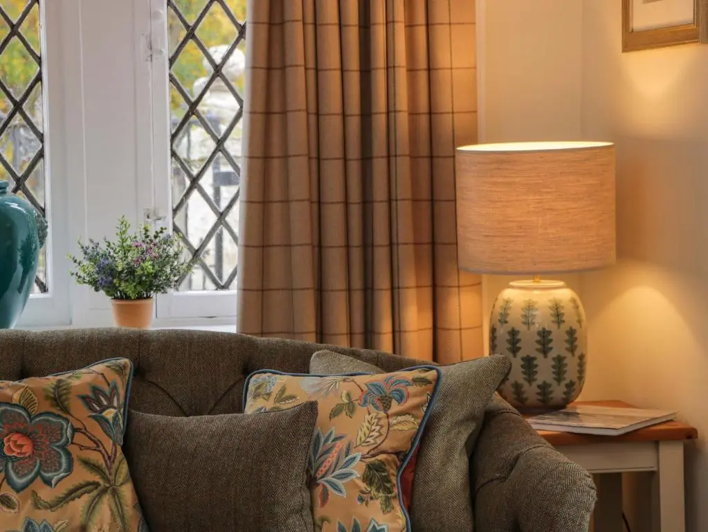 a living room with a couch and a lamp at East Lodge - Crathes Castle in Banchory