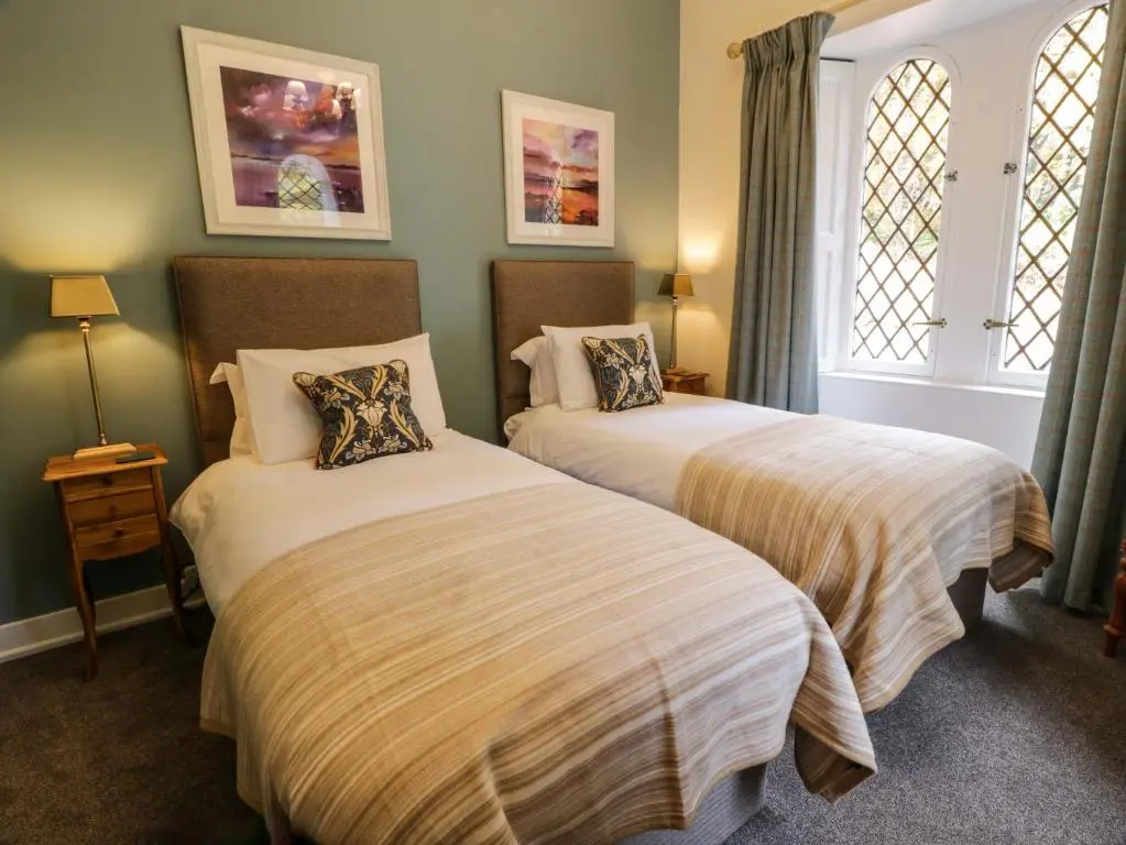 a bedroom with two beds and two windows at East Lodge - Crathes Castle in Banchory