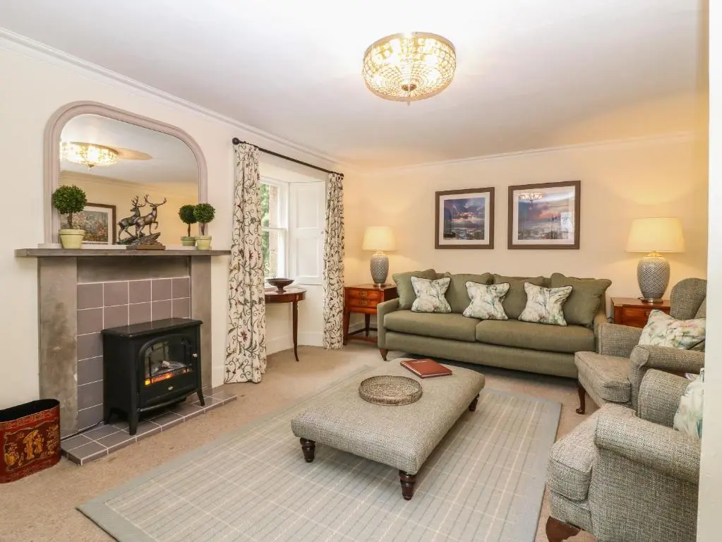 a living room with a couch and a fireplace at South Mains Cottage - Craigievar Castle in Alford