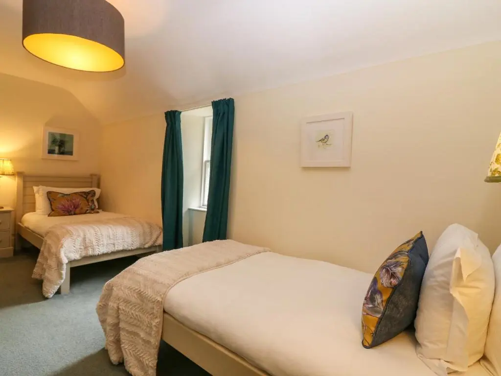 a bedroom with two beds and a window at South Mains Cottage - Craigievar Castle in Alford