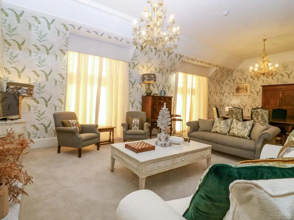 a living room filled with furniture and a chandelier at Braeriach - Mar Lodge Estate in Ballater