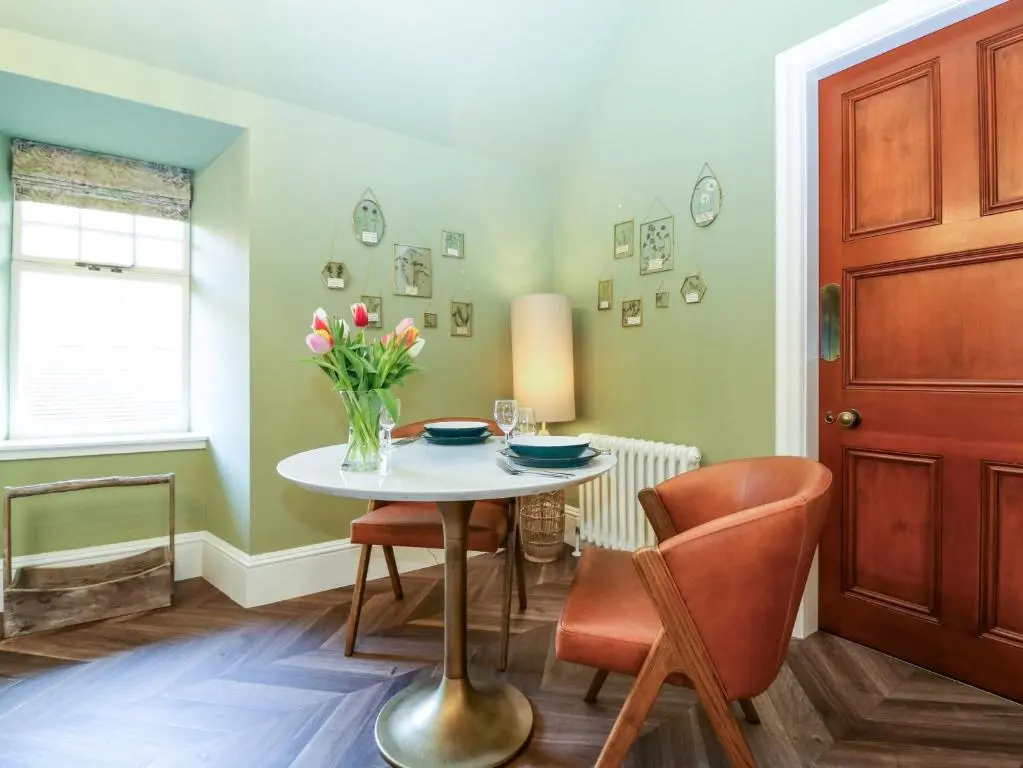 a dining room with a table and a vase of flowers at Braeriach - Mar Lodge Estate in Ballater