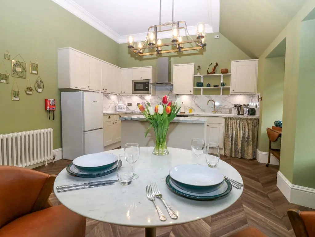 a kitchen with a table with plates and glasses at Braeriach - Mar Lodge Estate in Ballater