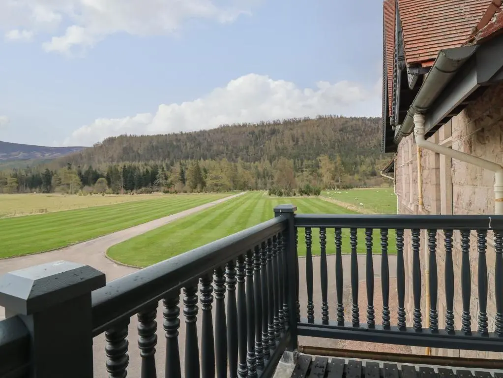 a balcony of a house with a view of a field at Macdui - Mar Lodge Estate in Ballater