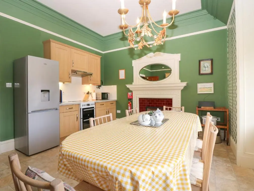 a kitchen with a table with a yellow and white table cloth at Macdui - Mar Lodge Estate in Ballater