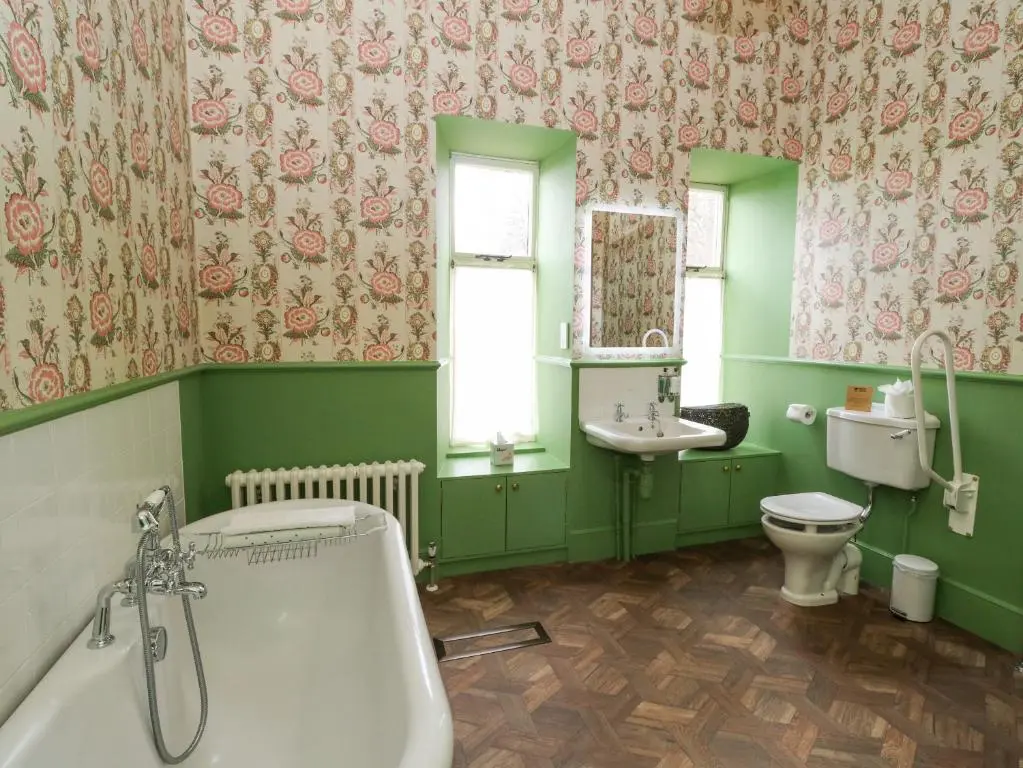 a green bathroom with a tub and a toilet at Derry - Mar Lodge Estate in Ballater