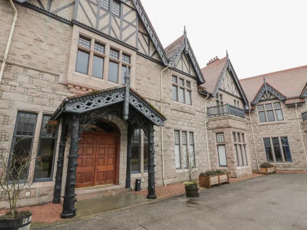 a large brick building with a wooden door at Derry - Mar Lodge Estate in Ballater