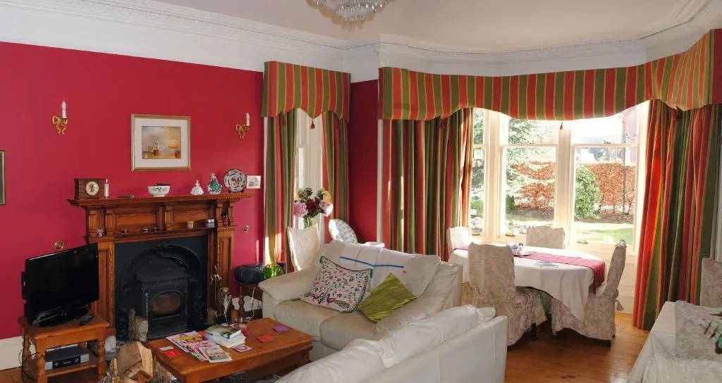 a living room with a couch and a fireplace at Chrialdon House in Beauly